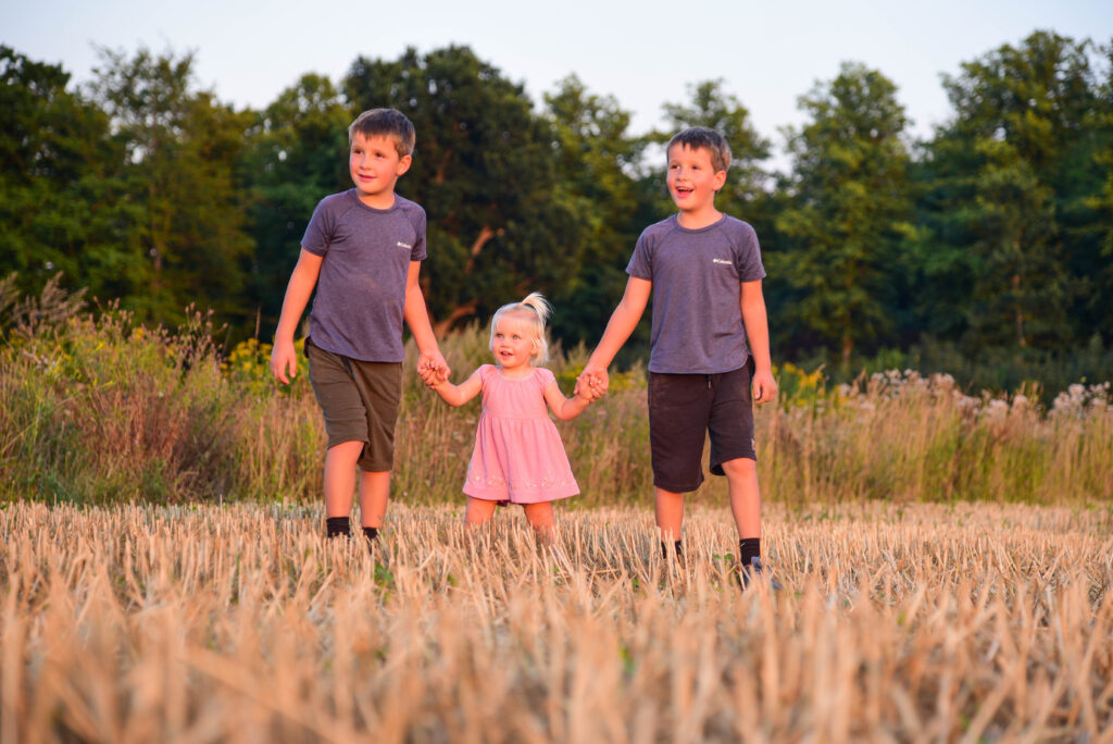 Geschwister auf Stoppelfeld beim Kinder-Shooting