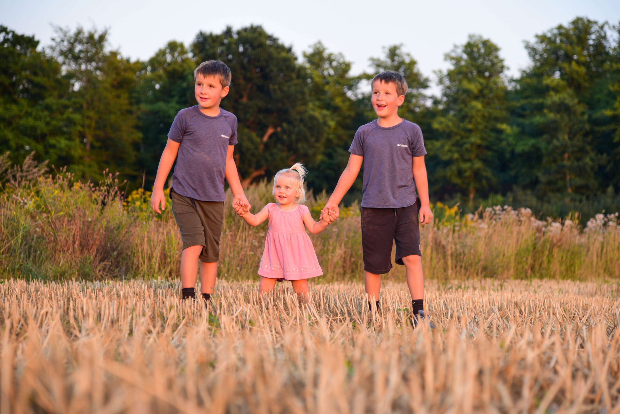 Geschwister auf Stoppelfeld beim Kinder-Shooting