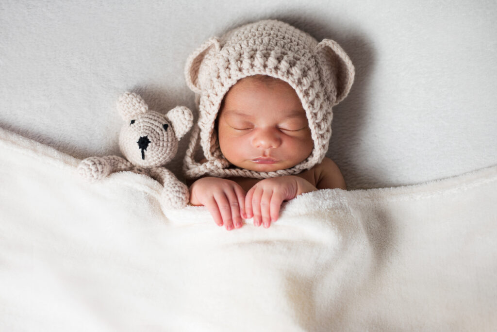 Baby mit Mütze und Teddy beim Neugeborenen-Shooting von Lotta&Anton Familienfotografie