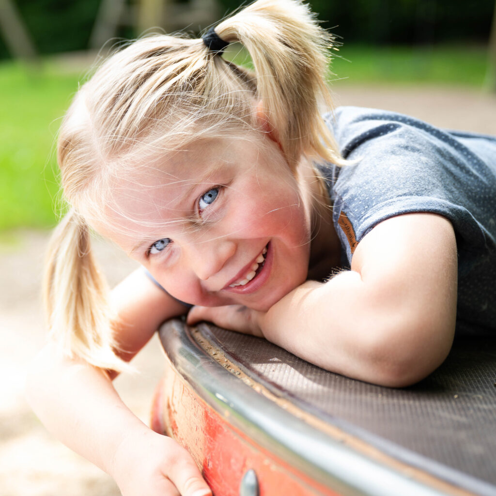 Lachendes Mädchen auf dem Spielplatz beim Kinder-Shooting von Lotta und Anton Familienfotografie