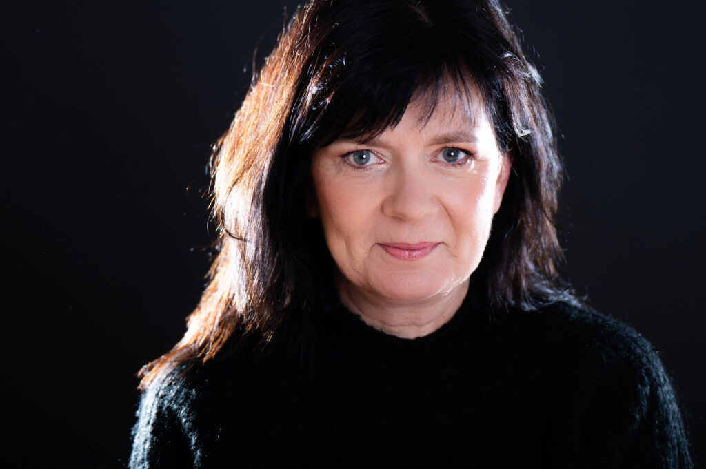 Portrait von Frau mit Gegenlicht vor schwarzem Hintergrund beim Business-Shooting