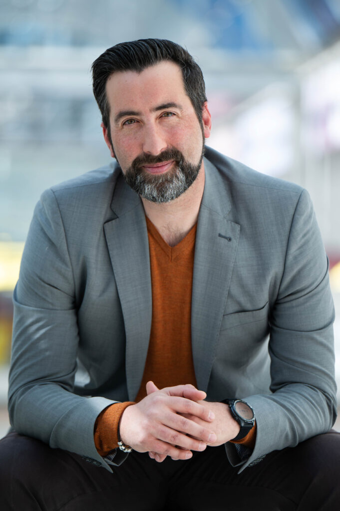 Mann vor Glasfassade sitzend beim Business-Shooting