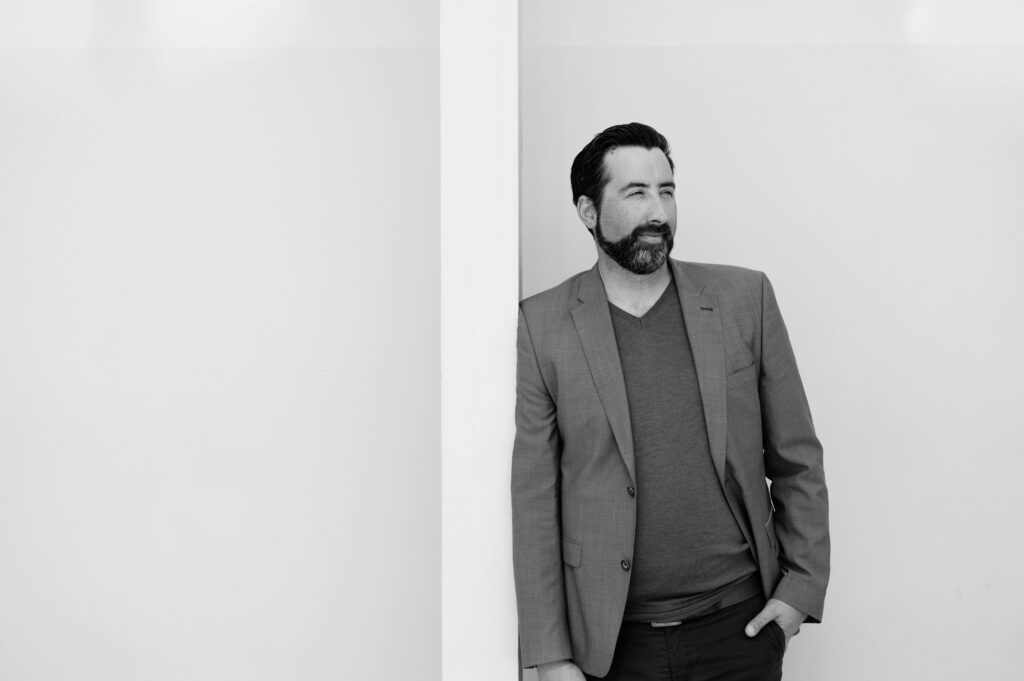 Mann lässig an Wand angelehnt beim Business-Shooting